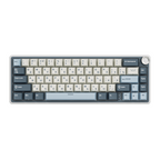 Compact mechanical keyboard with dark keycaps, beige highlights, and a metal volume knob